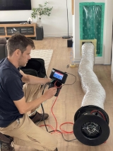 Researchers conducting a blower door test to identify leakage rate, and determine where leakages occur.